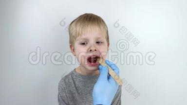 <strong>耳鼻喉</strong>科医生用木铲检查儿童`<strong>喉</strong>咙。 可能的诊断是咽炎，扁桃体发炎
